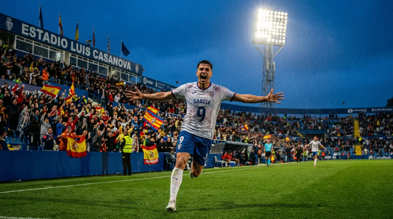 Jugador de fútbol celebrando un gol con los brazos alzados